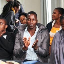 MRF scholar sitting in a crowd clapping